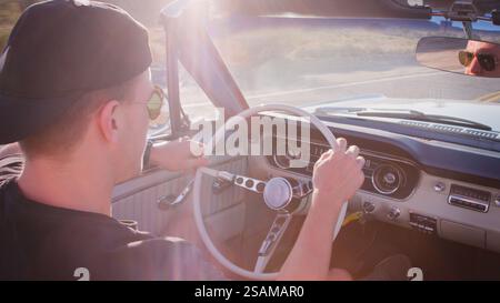 Rückansicht Des Jungen Mannes Auf Einer Fahrt Mit Dem Mietwagen Entlang Der Country Road Stockfoto