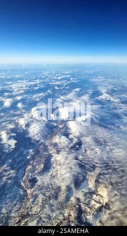 Midair, Osteuropa - 12. 20. 2024: Leichter Schnee auf Carpatihians unter den Wolken durch das Jetliner-Fenster. Stockfoto