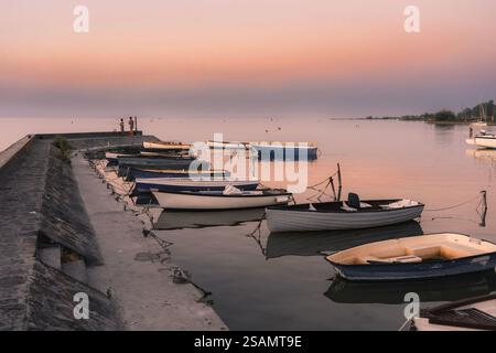 Ruhiges idyllisches Bild von Booten neben dem Pier bei Sonnenuntergang in Balatonlelle am Balaton. Stockfoto