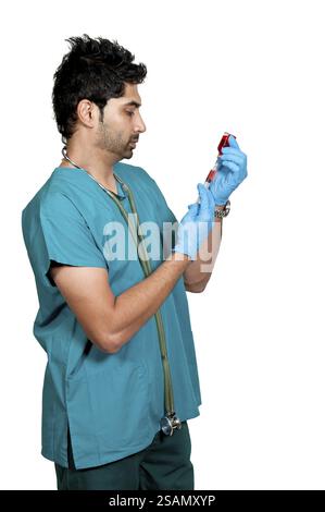 Junger Mann Arzt, der eine Patientenspritze vorbereitet Stockfoto
