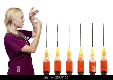 Eine schöne blonde Frau Ärztin vorbereitet eine Injektion in eine Spritze Stockfoto