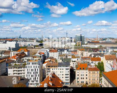 Stadtblick auf München mit Wohnhäusern, modernen Hochhäusern und Baustellen unter blauem Himmel - eine wachsende Metropole im Wandel Stockfoto