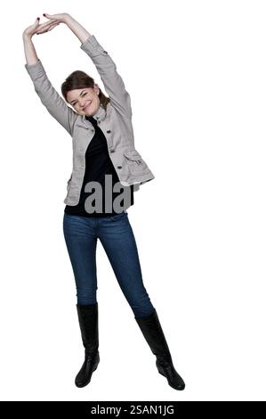 Schöne junge, müde Frau, die Arme und Beine spannt Stockfoto