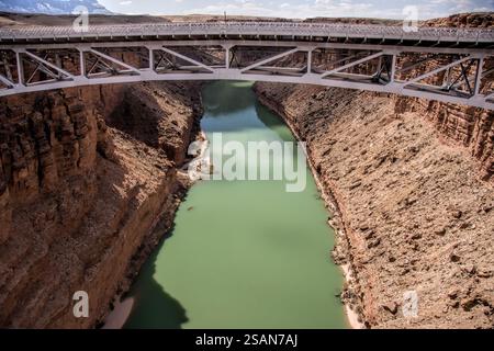 Eine Brücke über einen Fluss in grüner Farbe. Die Brücke besteht aus Metall. Der Fluss ist breit und tief Stockfoto