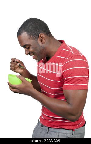 Junger schwarzer Afroamerikaner, der Essen aus einer Schüssel isst Stockfoto