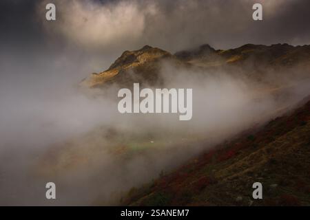 Ein nebeliger Sonnenaufgang über dem Egrisi-Gebirge in Samegrelo, Georgia. Schroffe Gipfel des Großkaukasus erheben sich über dichte Wälder, die in Nebel gehüllt sind. Stockfoto