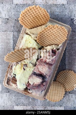 Verschiedene Eissorten und knusprige Waffelscheiben auf dem Tisch. Direkt darüber. Stockfoto