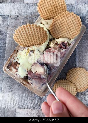 Verschiedene Eissorten und knusprige Waffelscheiben auf dem Tisch. Direkt darüber. Stockfoto