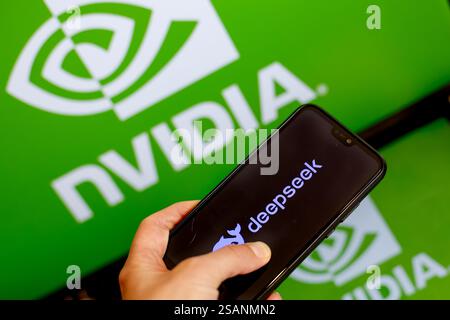In dieser Fotoabbildung wird das Nvidia-Logo auf zwei Computerbildschirmen gegenüber dem DeepSeek-Logo auf einem Mobiltelefon gezeigt, wie China vorstellt Stockfoto