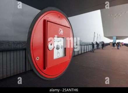 Feueralarm an Glastür, reflektierend, in einem Gebäude im Hafen. Hamburg, Deutschland. Stockfoto
