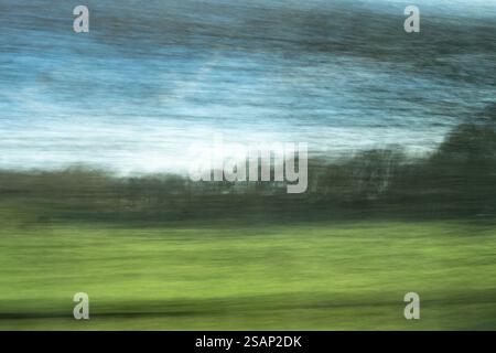 Fahrt durch die Landschaft im Winter Konzept - verschwommene Bäume durch Fenster und Felder außerhalb großbritanniens Stockfoto