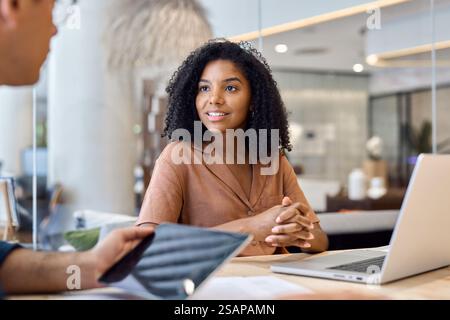 Junge afroamerikanische Geschäftsmanagerin, die bei einem Meeting mit einem Kollegen arbeitet. Stockfoto
