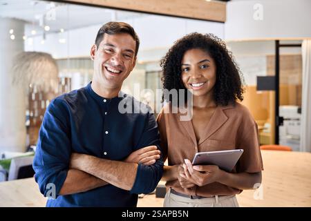 Zwei junge, vielfältige Geschäftsleute, die im Büro stehen, Porträt. Stockfoto