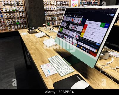 Kiew, Ukraine - 30. Januar 2025: Moderner Apple Desktop-Computer auf einem Holzschreibtisch in einem Technologieladen, mit lebhaftem Monitor, Tastatur, A Stockfoto