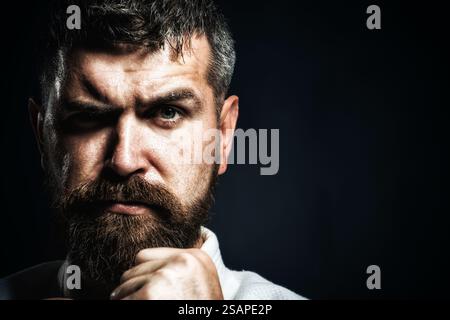 Karate-Mann. Nahaufnahme Porträt eines starken Karatelehrers mit geballten Fäusten. Karate-Kämpfer, der sich auf den Wettkampf im Fitnessstudio vorbereitet. Ernsthafter Karatemeister Stockfoto
