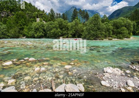 Ein ruhiger Fluss Soca fließt durch eine lebhafte Landschaft voller üppiger Bäume und felsiger Bachbetten. Slowenien, Europa. Stockfoto