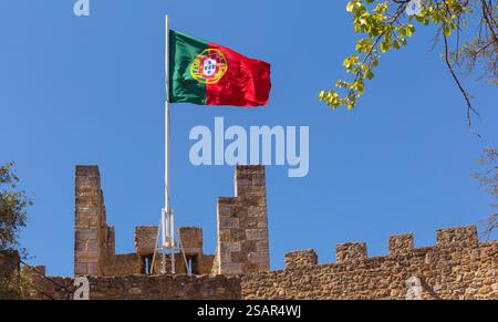 Die portugiesische Nationalflagge auf den mittelalterlichen Mauern des Schlosses Sao Jorge in Lissabon, Portugal Stockfoto