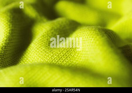 Nahaufnahme, handgestrickt in lebendigen Zitronentönen. Federfarbe. Horizontale, leuchtend gelbe Strickstruktur als Hintergrund. Reale Horizontalität Stockfoto