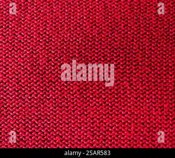 Textur von rotem Strickgewebe als Hintergrund, Draufsicht. Reales horizontales Bild. Nahaufnahme, handgestrickt in leuchtendem Rot. Strukturierter Hintergrund Co Stockfoto
