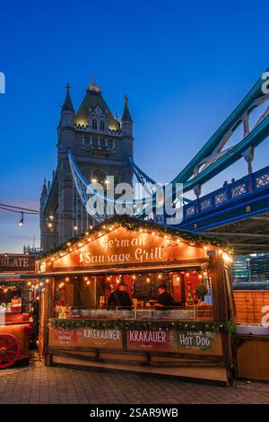 London, Großbritannien - 25. November 2024: Weihnachtsmarkt in der Nähe der Tower Bridge mit Holzbuden mit festlichen Dekorationen. Kultig Stockfoto