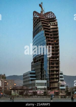 Ein hohes Gebäude mit vielen Fenstern wird gebaut. Der Himmel ist blau und die Sonne untergeht Stockfoto