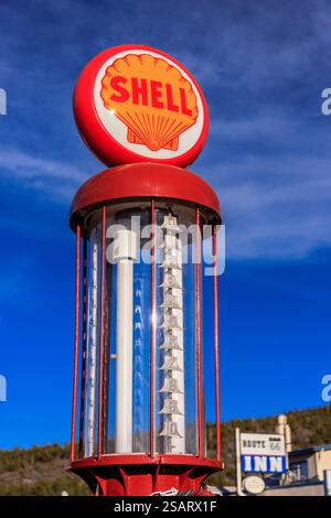 Shell Tankstelle mit einem rot-weißen Schild. Das Schild ist auf einer hohen Stange. Der Himmel ist blau und es gibt keine Wolken Stockfoto