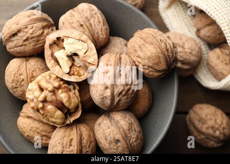 Frische Walnüsse in Schüssel und Beutel auf dem Tisch, flach gelegt Stockfoto
