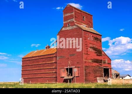 Ein rotes Getreidesilo mit blauem Himmel im Hintergrund. Das Silo ist alt und hat ein rustikales Aussehen Stockfoto