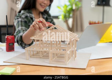 Architekt macht Architekturmodell. Daten funktionieren und Tablet-Notebook. Architekt erklärt den Projektplan den Kunden. Selbstbewusste Geschäftsfrau, die AR hält Stockfoto