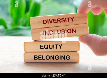 Handauflage Kultivieren von Vielfalt, Inklusion, Gleichheit und zugehörigem Text auf Holzblöcken. D- und I-Konzept. Stockfoto