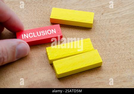 Einschließungstext von Hand mit den restlichen gelben Holzblöcken. D- und I-Konzept. Stockfoto