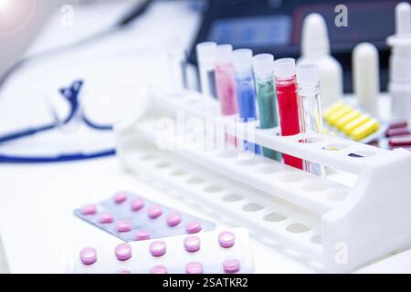 Pillen und bunte Reagenzgläser in Laborumgebung Stockfoto