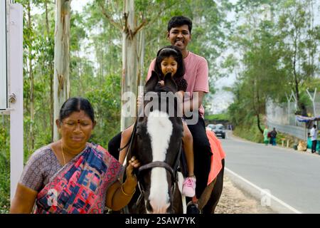 Dieses Bild zeigt eine indische Familie, die auf einer belebten Straße auf einem Pferd reitet Stockfoto