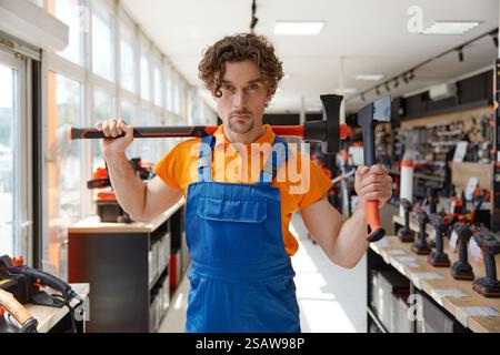Mann Arbeiter, der Holzfäller Axt von hoher Qualität in einem Eisenwarenladen anbietet Stockfoto