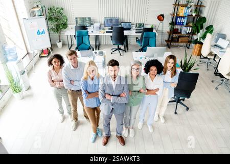 Vielseitiges Team von Fachleuten, das sich selbstbewusst in einem modernen Büroumfeld ausgibt, das mehrere Jahre alt ist Stockfoto
