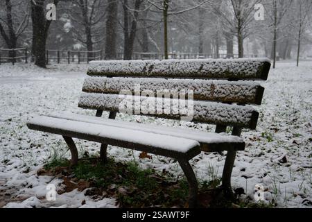 parkbank auf einer Wintergasse bei Schneefall Stockfoto