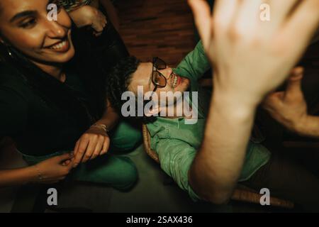 Lächelnde Freunde treffen sich zu einer fröhlichen Geburtstagsfeier zu Hause Stockfoto