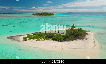 Aus der Vogelperspektive eine tropische Insel umgeben von lebendigem türkisfarbenem Wasser, mit einem kleinen Sandstrand, an dem die dringende Nachricht Hilfe in den Sand geschrieben ist Stockfoto