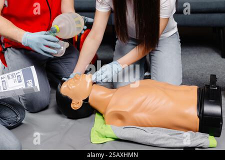 Frau hält Atembeutel Ambu Bag.demonstriert HLW Herz-Lungen-Wiederbelebung Training medizinische Prozedur auf HLW Puppe in der Klasse.Sanitäter dem Stockfoto