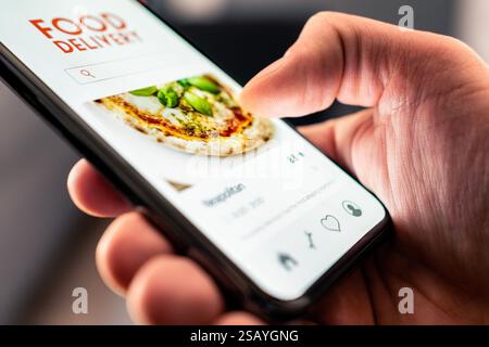 Lieferung von Speisen und Pizza mit Telefon vom Restaurant. Online-App bestellen. Auf der Website gibt es ein Menü zum Mitnehmen. Schneller Service zum Abnehmen. Schnelle Zustellung nach Hause. Stockfoto