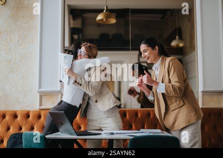Weibliche Kollegen feiern Erfolg mit Freude und Kameradschaft im Büro Stockfoto