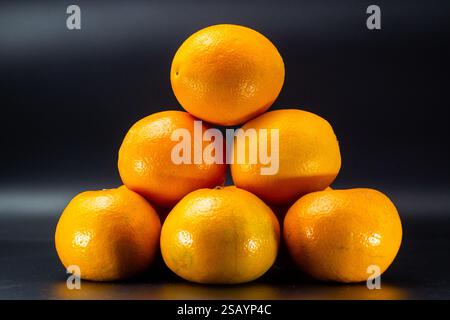 Frische Orangen, isoliert auf schwarzem Hintergrund Stockfoto