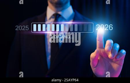 Eine Person, die auf einen Ladebalken zeigt und von 2025 auf 2026 wechselt. Konzept des Fortschritts, der Zukunftsplanung und der Festlegung von Neujahrszielen für Unternehmen und Stockfoto