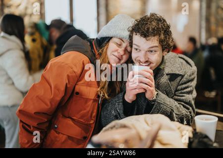 Ein Paar genießt während eines gemütlichen Wintertages im Haus warme Getränke Stockfoto
