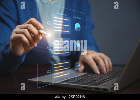 Dokument-Checkliste online. Eine Person arbeitet an einem Laptop und interagiert mit virtuellen Elementen auf dem Bildschirm. Auf dem Bildschirm werden Aufgaben und deren Status angezeigt Stockfoto