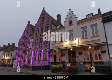 Restaurant mit Weihnachtsdekoration auf dem Marktplatz, historische Häuser mit beleuchteten Fassaden, Dämmerung, Damme, Westflandern, Flandern, Belgiu Stockfoto
