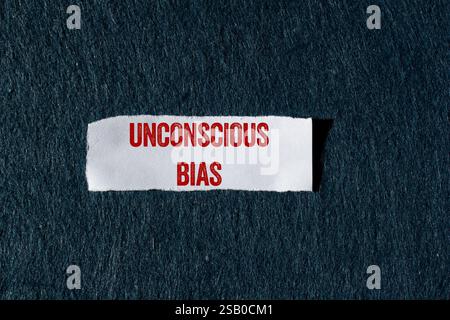 Unbewusste Vorurteilsmeldung auf zerrissenem Papierstück mit grauem Hintergrund. Konzeptuelles unbewusstes Vorurteil-Symbol. Kopierbereich. Stockfoto