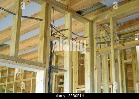Studwalls werden in einem neuen Fachwerkhaus in Großbritannien gebaut. Brettschichtholz-Dach. Elektrische Verkabelung zwischen Bolzen. Stockfoto