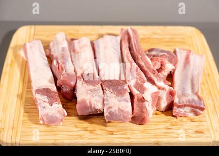 Ein großes Stück Fleisch wurde in dünne Streifen geschnitten und auf ein hölzernes Schneidebrett gelegt. Das Fleisch ist so angeordnet, dass es wie ein Sta aussieht Stockfoto
