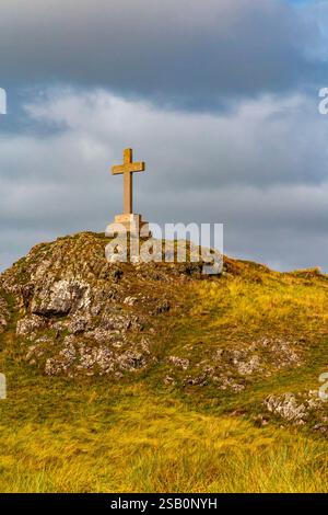 Hügelige Landschaft mit Kreuz auf Ynys Llanddwyn, einer kleinen Insel vor der Küste von Anglesey in Nordwales, Großbritannien. Stockfoto